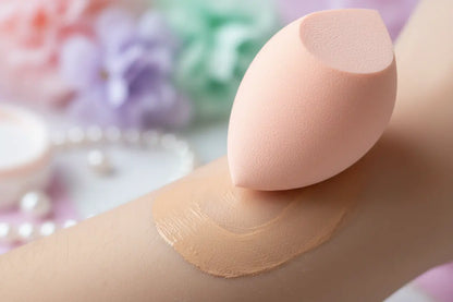 Close-up of makeup sponge blending foundation showing soft texture and application technique